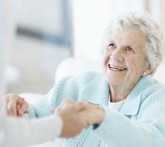 Elderly woman receiving help from health care worker