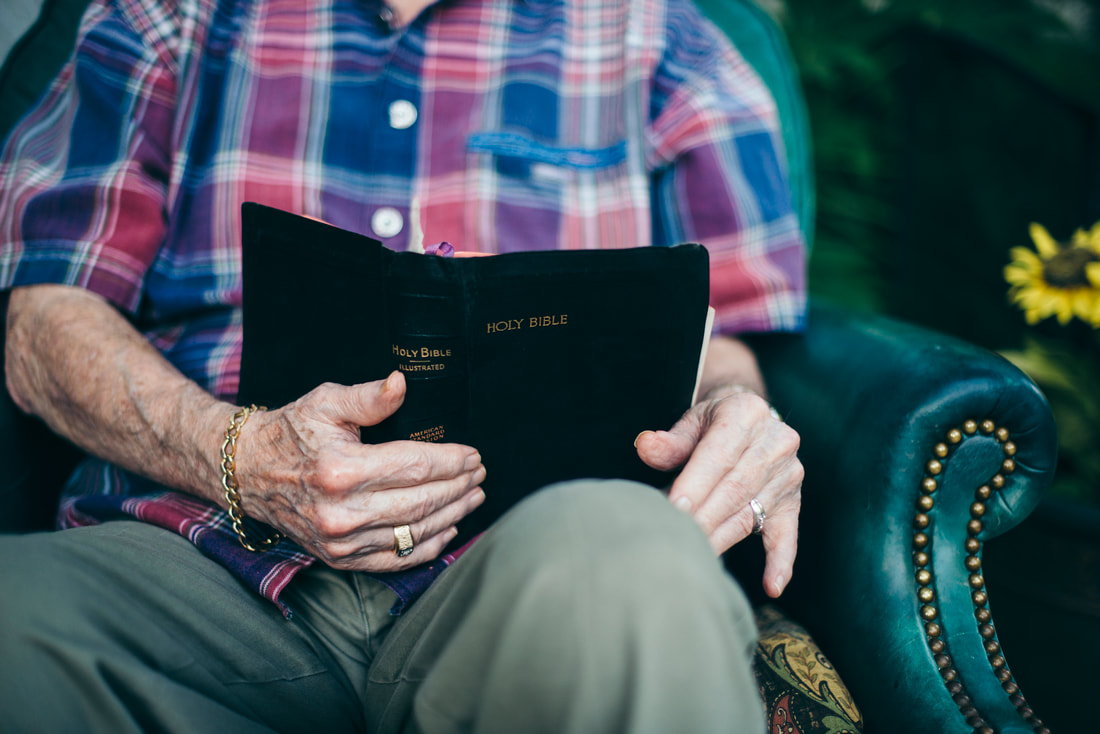 Elderly man reading a bible