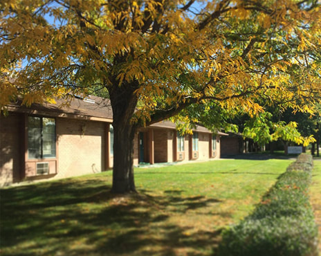 The Front of The Vineyards Memory Care Facility with Grass and a Tree